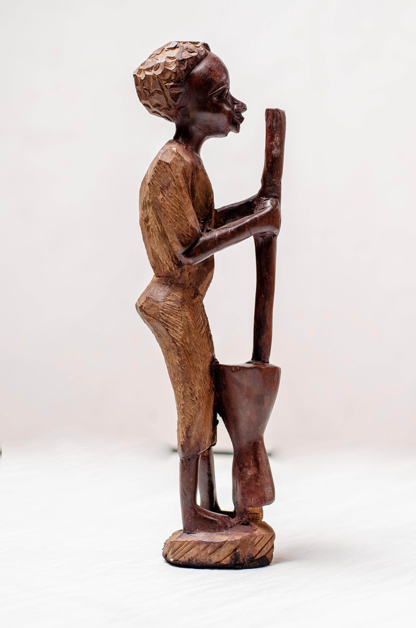 A SCULPTURE OF A MAIDEN AFRICAN WOMAN POUNDING - MADE OUT OF AUTHENTIC RAW IRON WOOD - PRODUCT PARADISE STORE